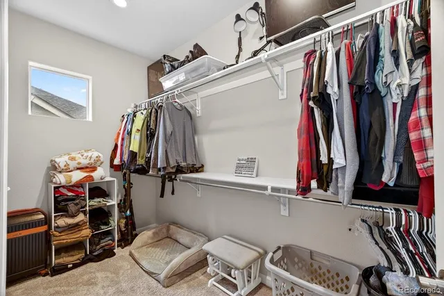 a view of walk in closet with clothes and shoes