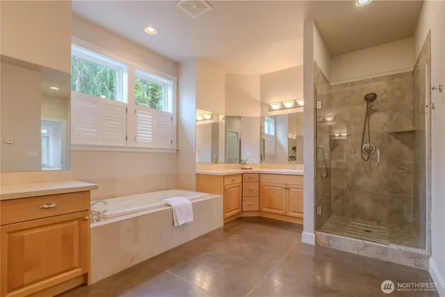 a bathroom with a granite countertop sink a toilet a large mirror and shower