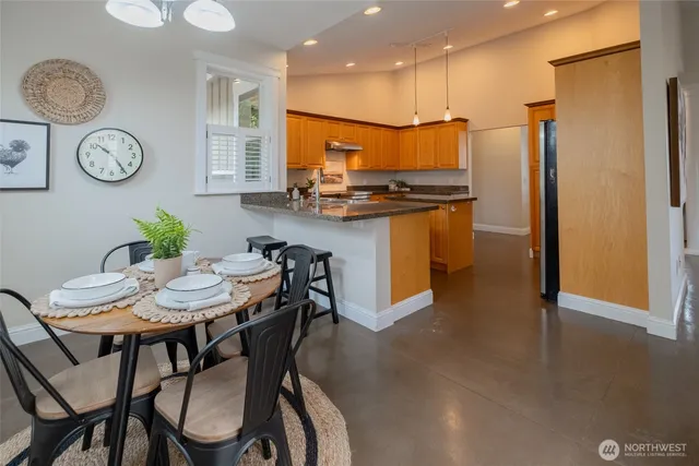 a view of a dining room with furniture a kitchen and chandelier