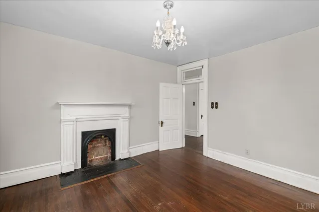 a view of a livingroom with a fireplace window and wooden floor