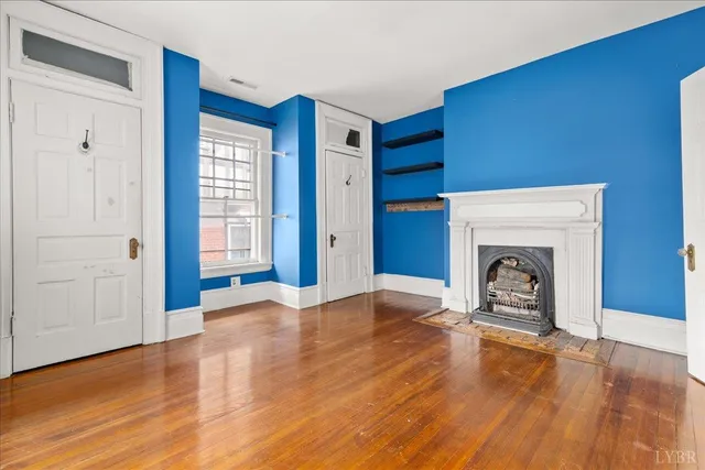 an empty room with wooden floor and window