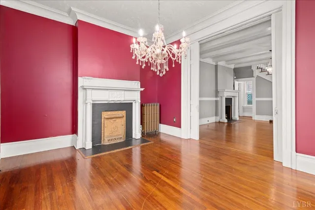 a view of a livingroom with wooden floor a fireplace and window