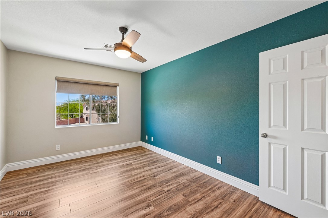 1176 Butternut Ranch Court Henderson, NV 89052 - Photo 23 of 60 An inviting room features a functional ceiling fan, durable wood flooring, and a window with outside views.