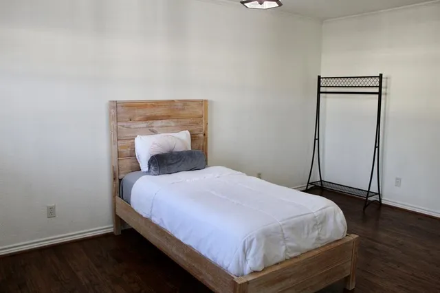 a bedroom with a bed and wooden floor