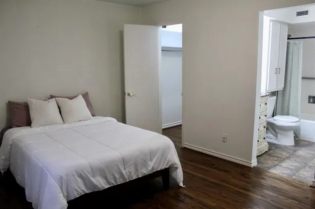a bedroom with a bed and wooden floor
