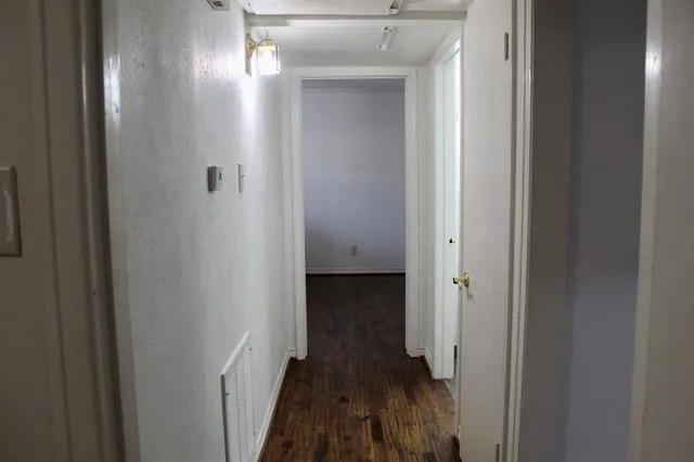 a view of a hallway with wooden floor