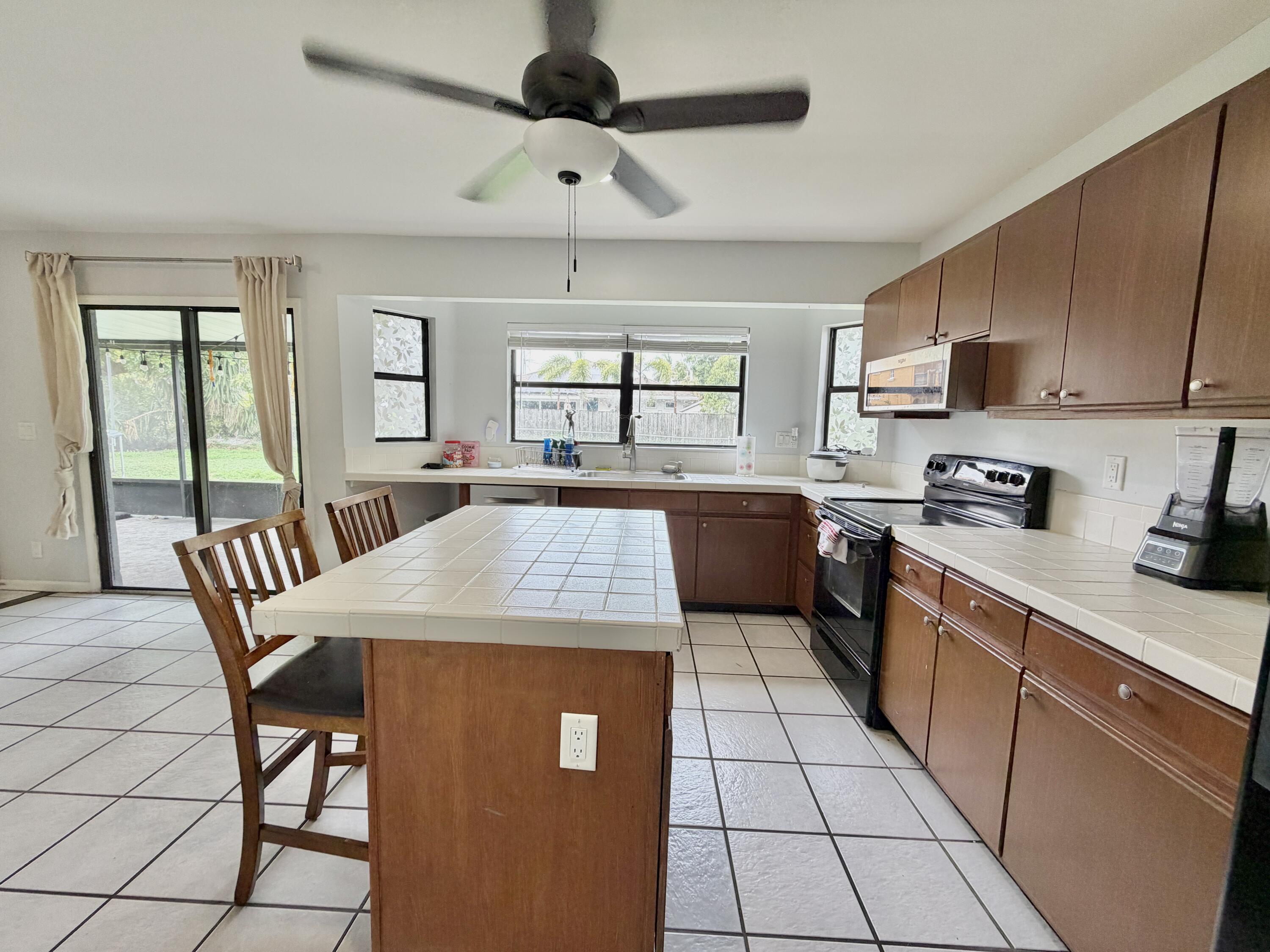 6048 Garrett Street Jupiter, FL 33458 - Photo 11 of 39 a kitchen with a table chairs and a refrigerator
