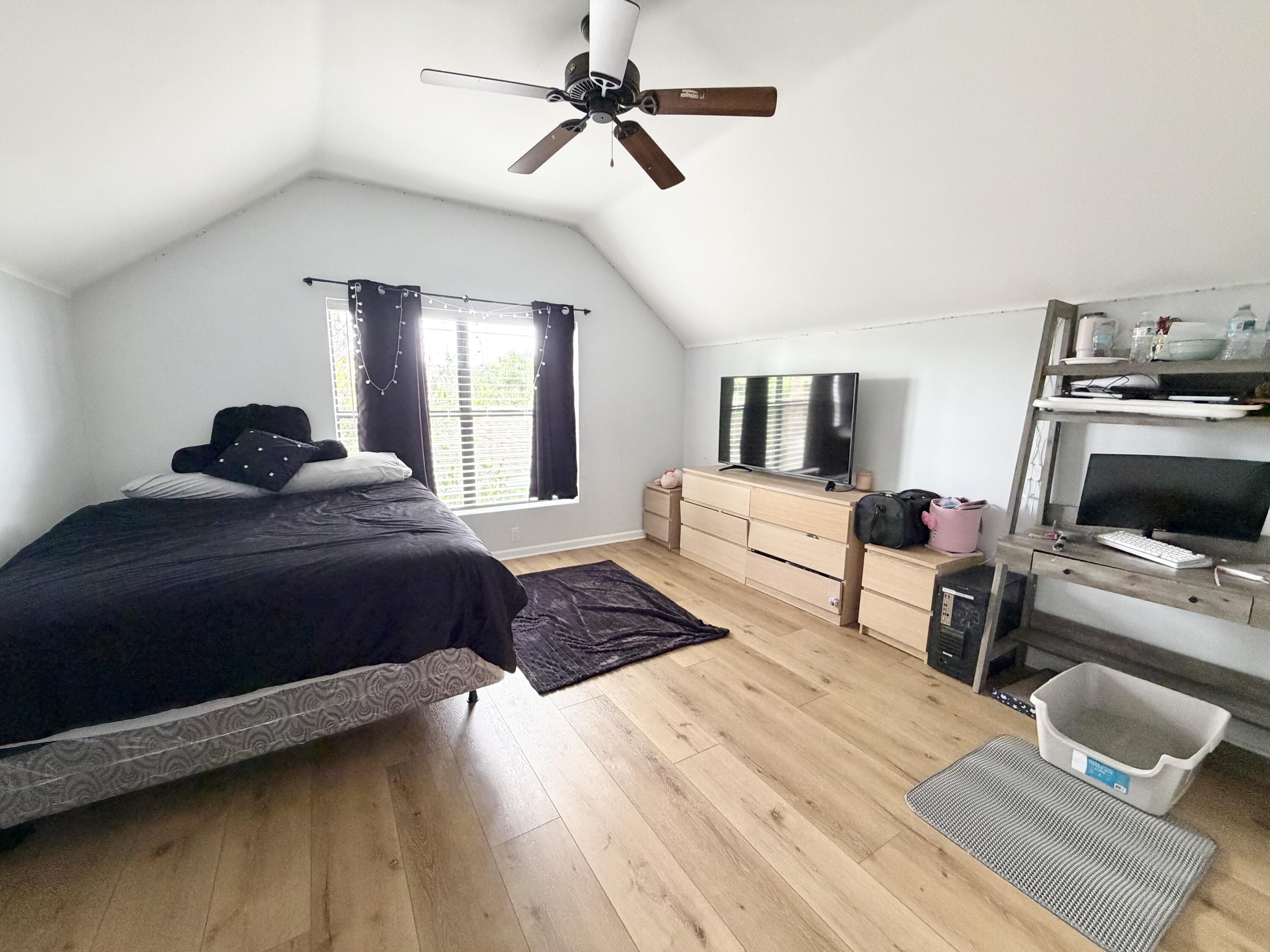 6048 Garrett Street Jupiter, FL 33458 - Photo 27 of 39 a bedroom with a bed and wooden floor