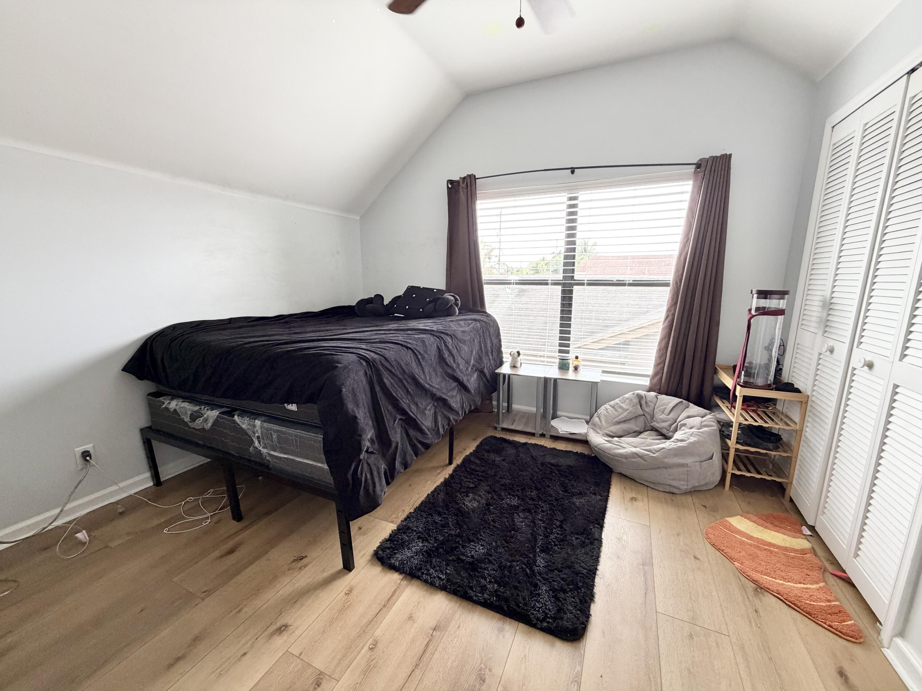 6048 Garrett Street Jupiter, FL 33458 - Photo 30 of 39 a spacious bedroom with a bed and wooden floor