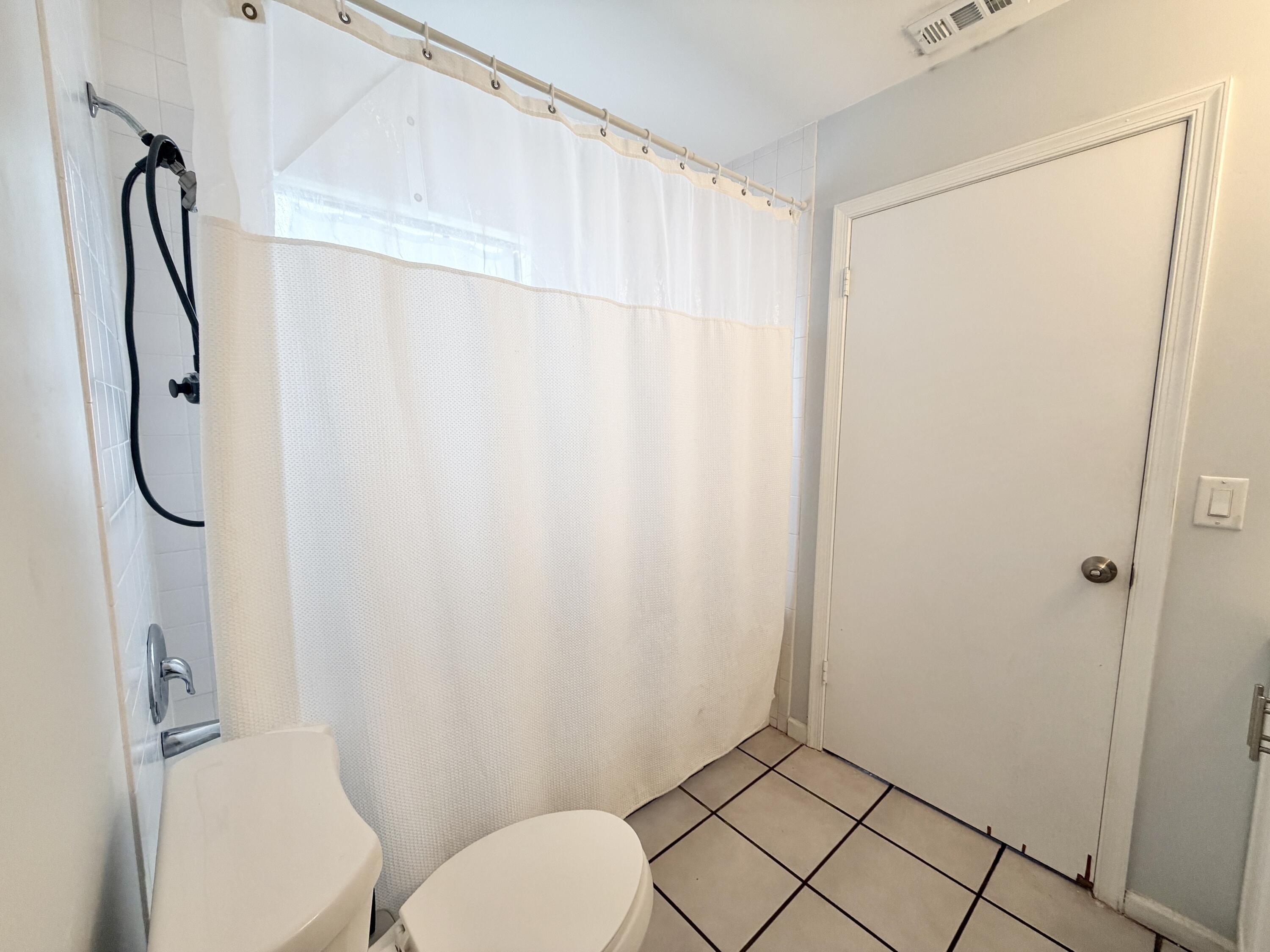 6048 Garrett Street Jupiter, FL 33458 - Photo 32 of 39 a bathroom with a toilet and a shower