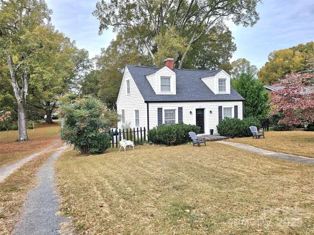 a front view of a house with a yard and trees