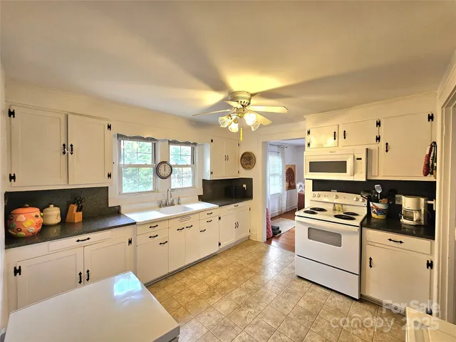 a kitchen with granite countertop a sink stove and refrigerator