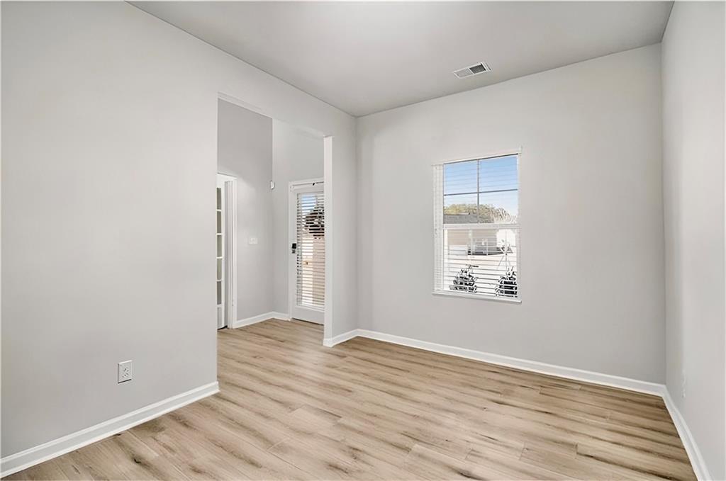 1101 Longleaf Trace Monroe, GA 30656 - Photo 11 of 36 a view of an empty room with wooden floor and a window