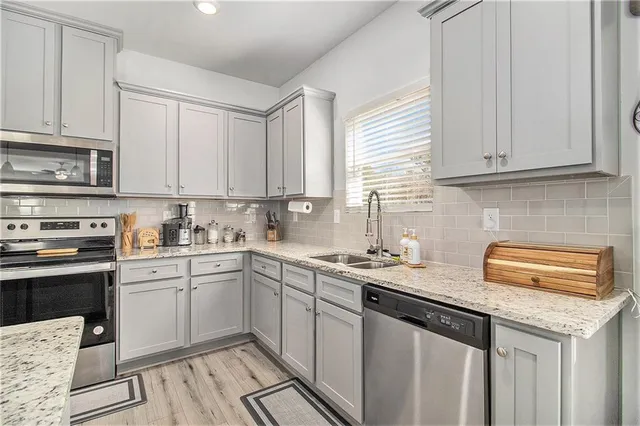 a kitchen with stainless steel appliances granite countertop a sink stove and cabinets