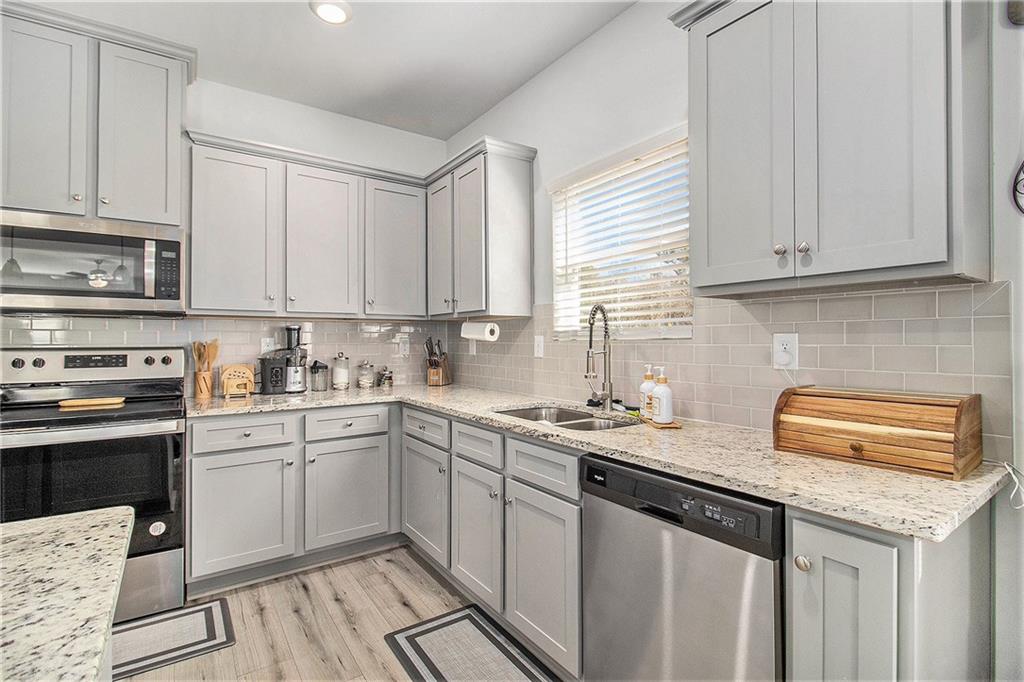 1101 Longleaf Trace Monroe, GA 30656 - Photo 15 of 36 a kitchen with stainless steel appliances granite countertop a sink stove and cabinets