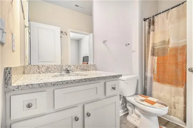 a bathroom with a granite countertop sink toilet and shower