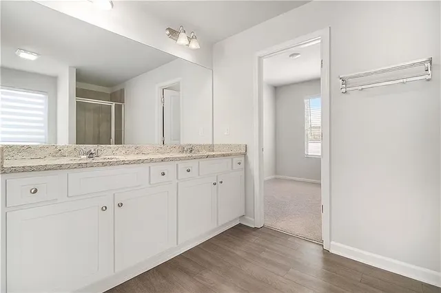 a bathroom with a granite countertop sink and mirror