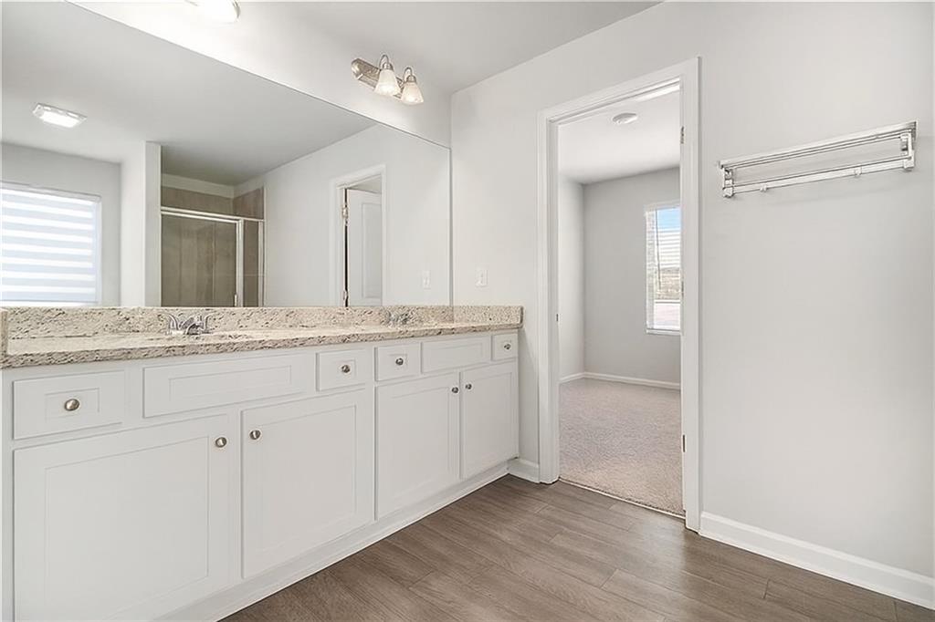 1101 Longleaf Trace Monroe, GA 30656 - Photo 25 of 36 a bathroom with a granite countertop sink and mirror