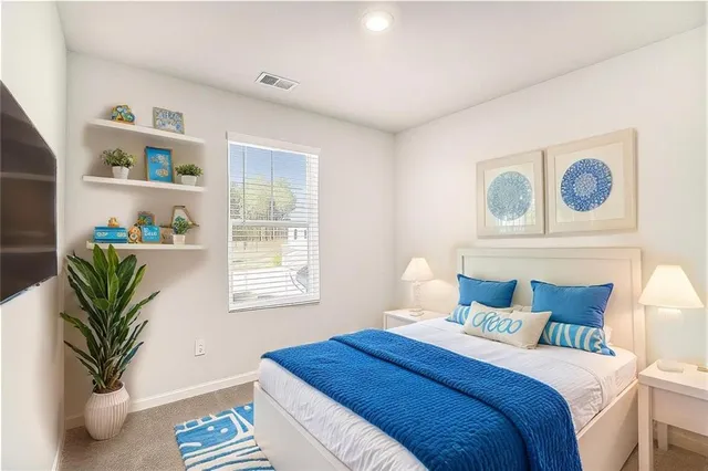 a bedroom with bed and a potted plant