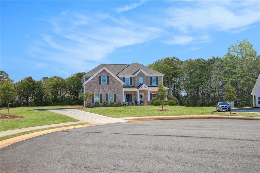 1101 Longleaf Trace Monroe, GA 30656 - Photo 4 of 36 a house with a yard and trees in the background