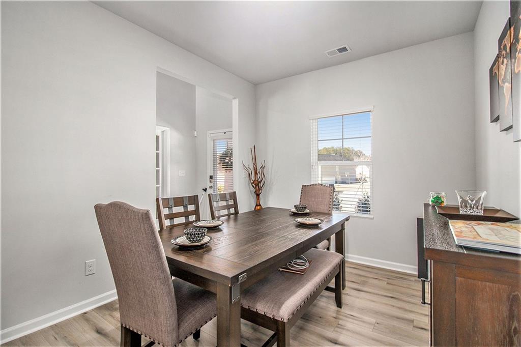 1101 Longleaf Trace Monroe, GA 30656 - Photo 10 of 36 a view of a dining room with furniture and wooden floor