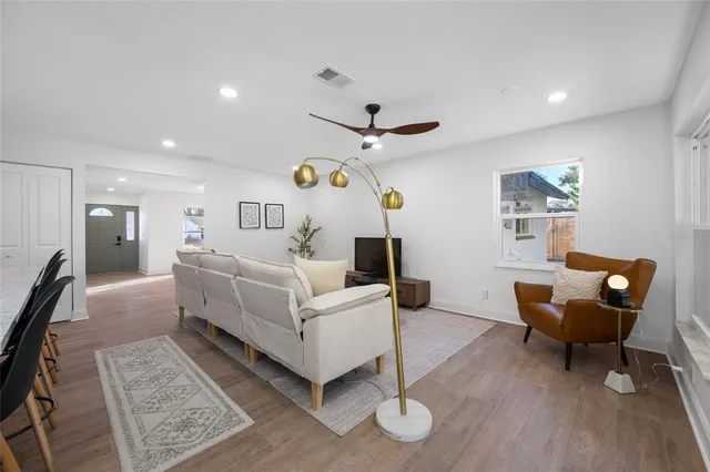a living room with furniture and a wooden floor