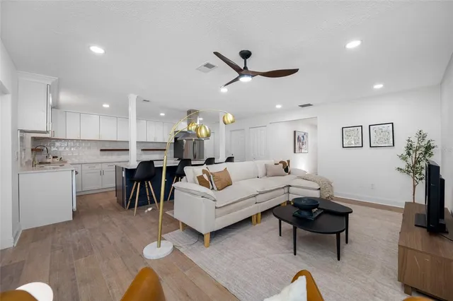 a living room with furniture kitchen view and a potted plant
