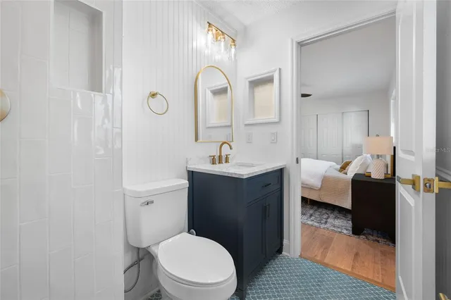 a bathroom with a toilet sink a mirror and vanity