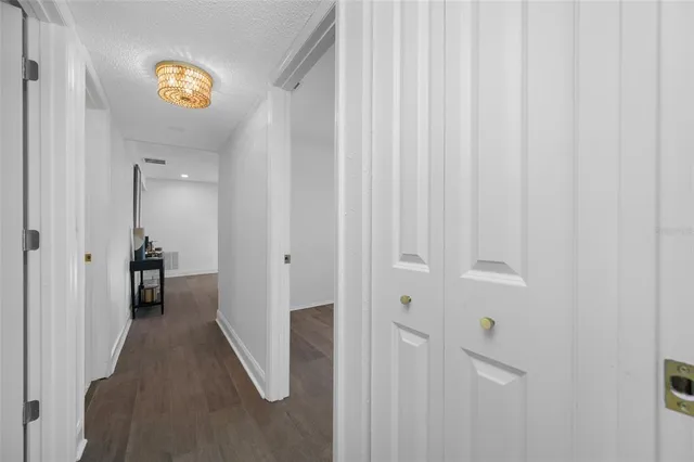 a view of a hallway with wooden floor and a bathroom view