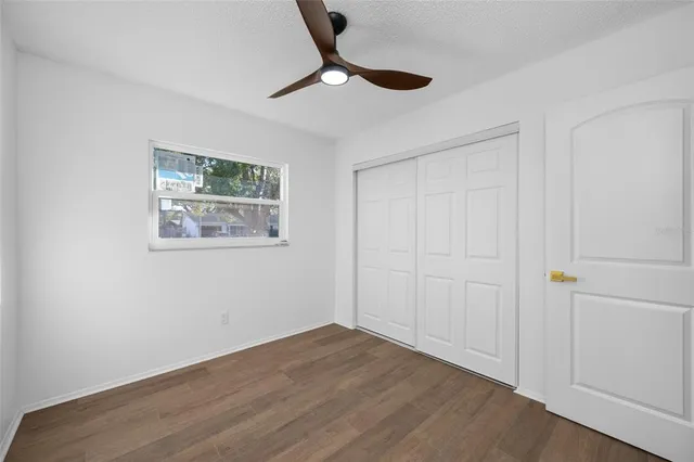 a view of empty room with wooden floor