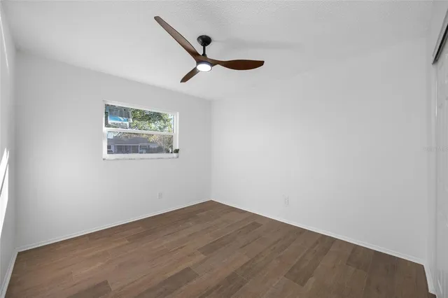 a view of empty room with wooden floor