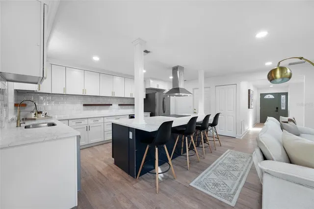 a kitchen with stainless steel appliances granite countertop a dining table chairs stove a sink and dishwasher