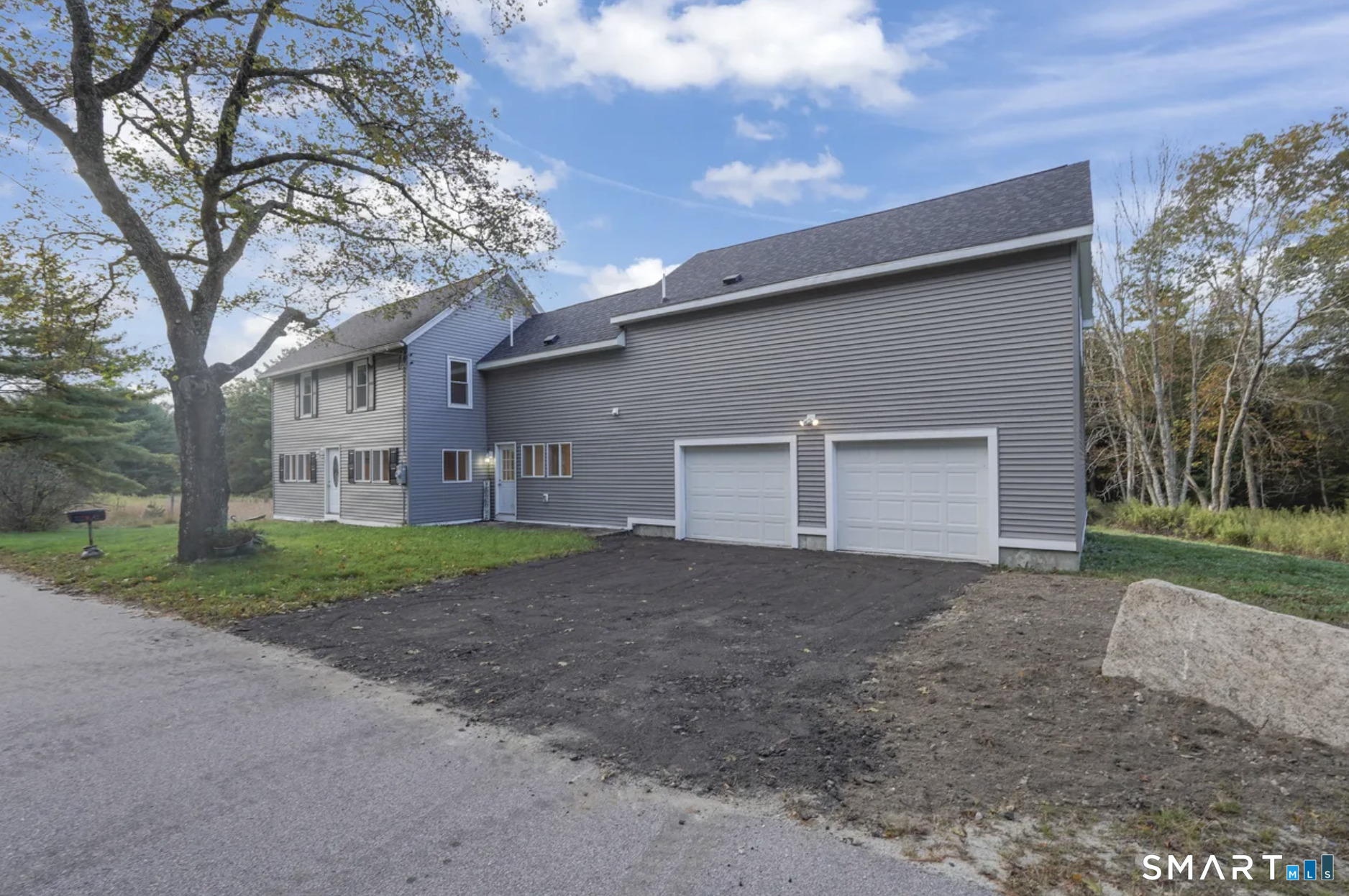a view of a house with a yard and large tree
