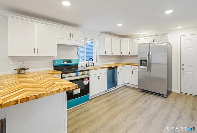 a kitchen with stainless steel appliances granite countertop a refrigerator sink and cabinets