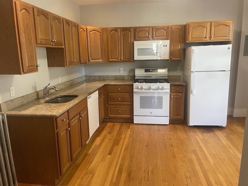 4 Blaney Street, Unit 2 Swampscott, MA 01907 - Photo 15 of 24 a kitchen with a sink a stove a refrigerator and cabinets