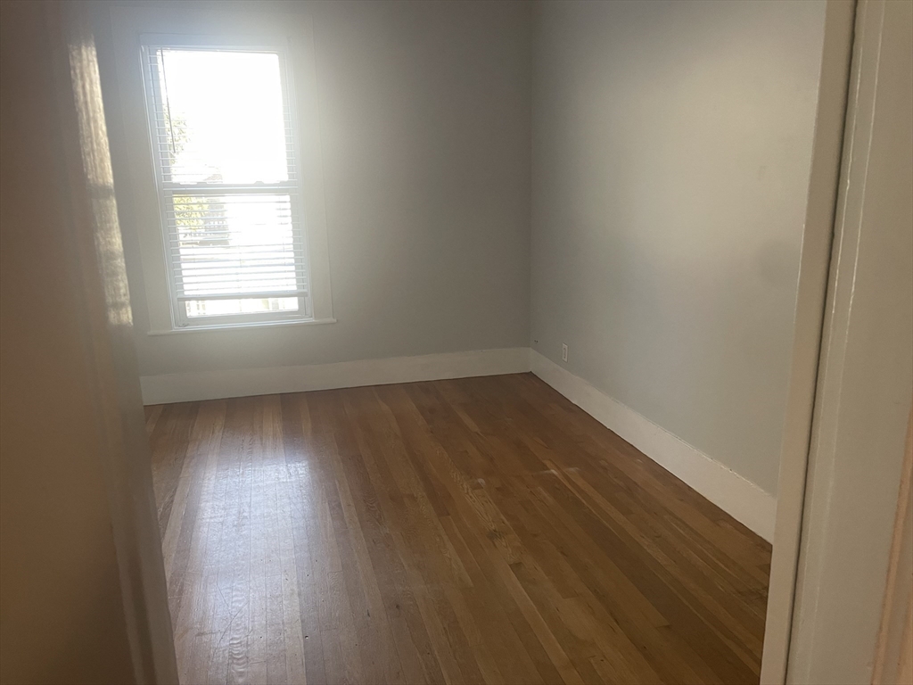 4 Blaney Street, Unit 2 Swampscott, MA 01907 - Photo 22 of 24 an empty room with wooden floor and windows