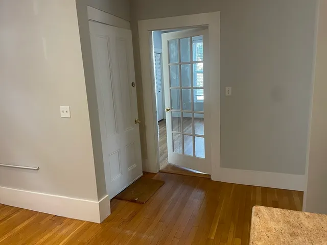 an empty room with wooden floor door and windows