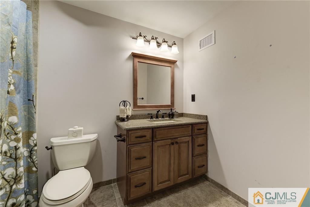 25 Crescent Road Old Bridge, NJ 08857 - Photo 20 of 25 a bathroom with a toilet sink vanity and mirror