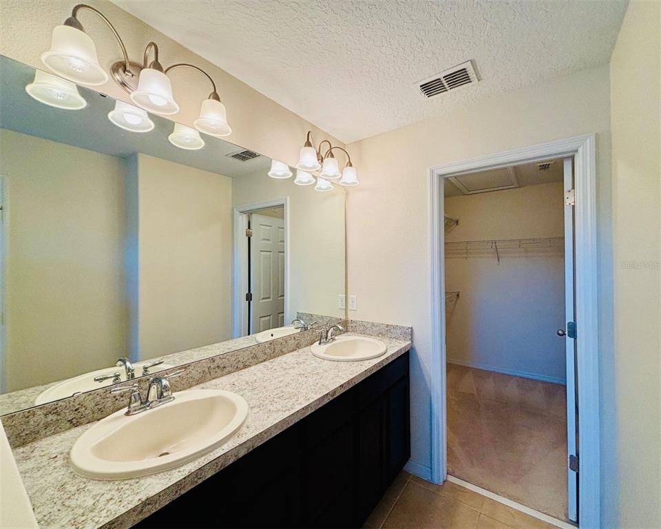 2144 Rookery Lane Sanford, FL 32773 - Photo 25 of 41 a bathroom with a granite countertop sink a large mirror and a shower