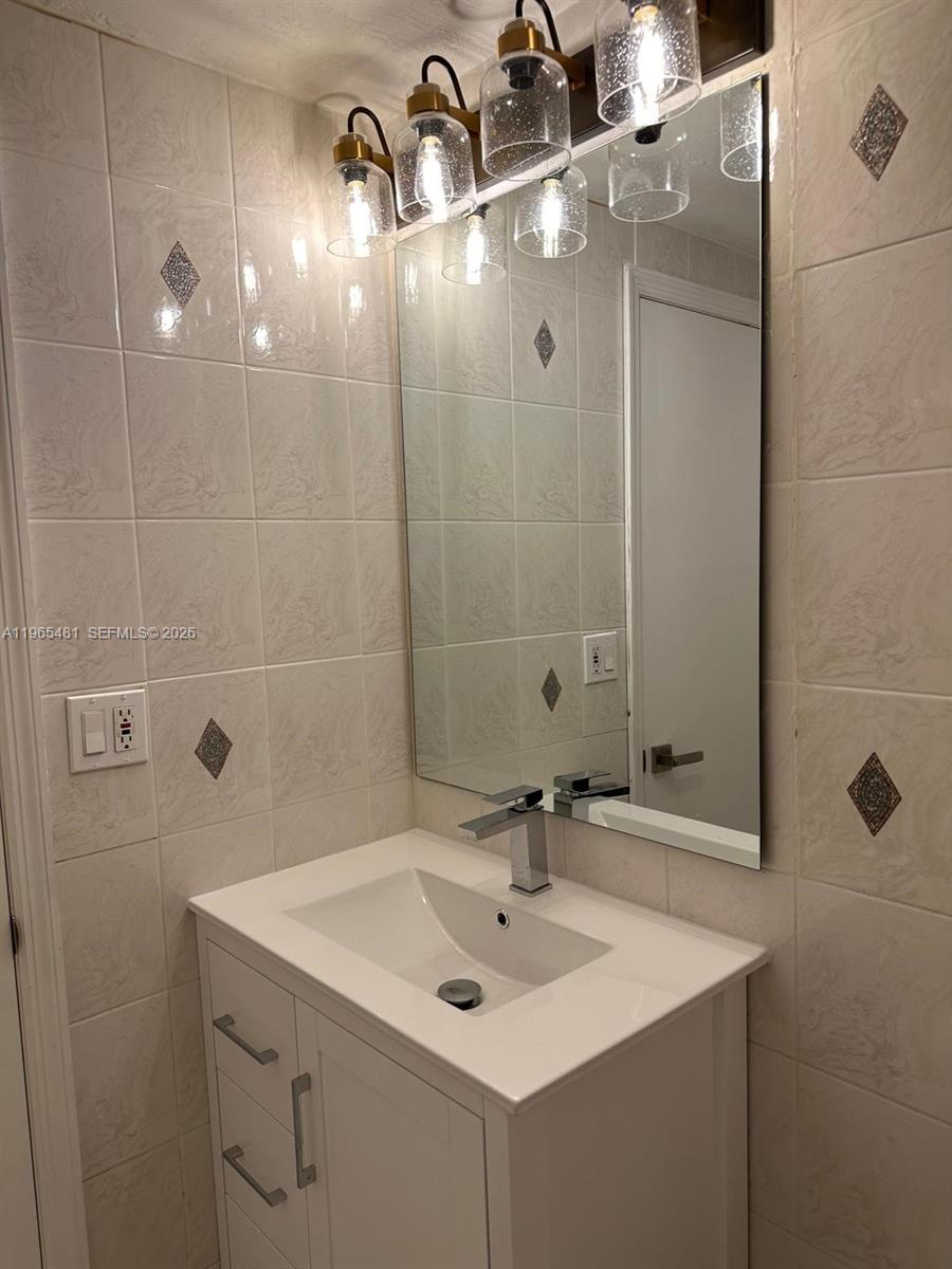 10916 Southwest 70th Terrace Miami, FL 33173 - Photo 12 of 39 a bathroom with a sink a mirror and shower