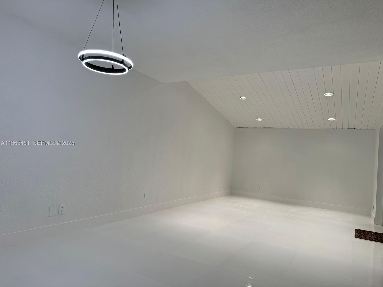 10916 Southwest 70th Terrace Miami, FL 33173 - Photo 6 of 39 an empty room with a chandelier fan and windows