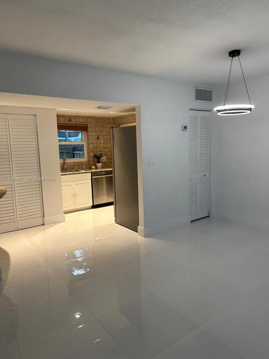 10916 Southwest 70th Terrace Miami, FL 33173 - Photo 10 of 39 a view of a kitchen with a sink and a refrigerator