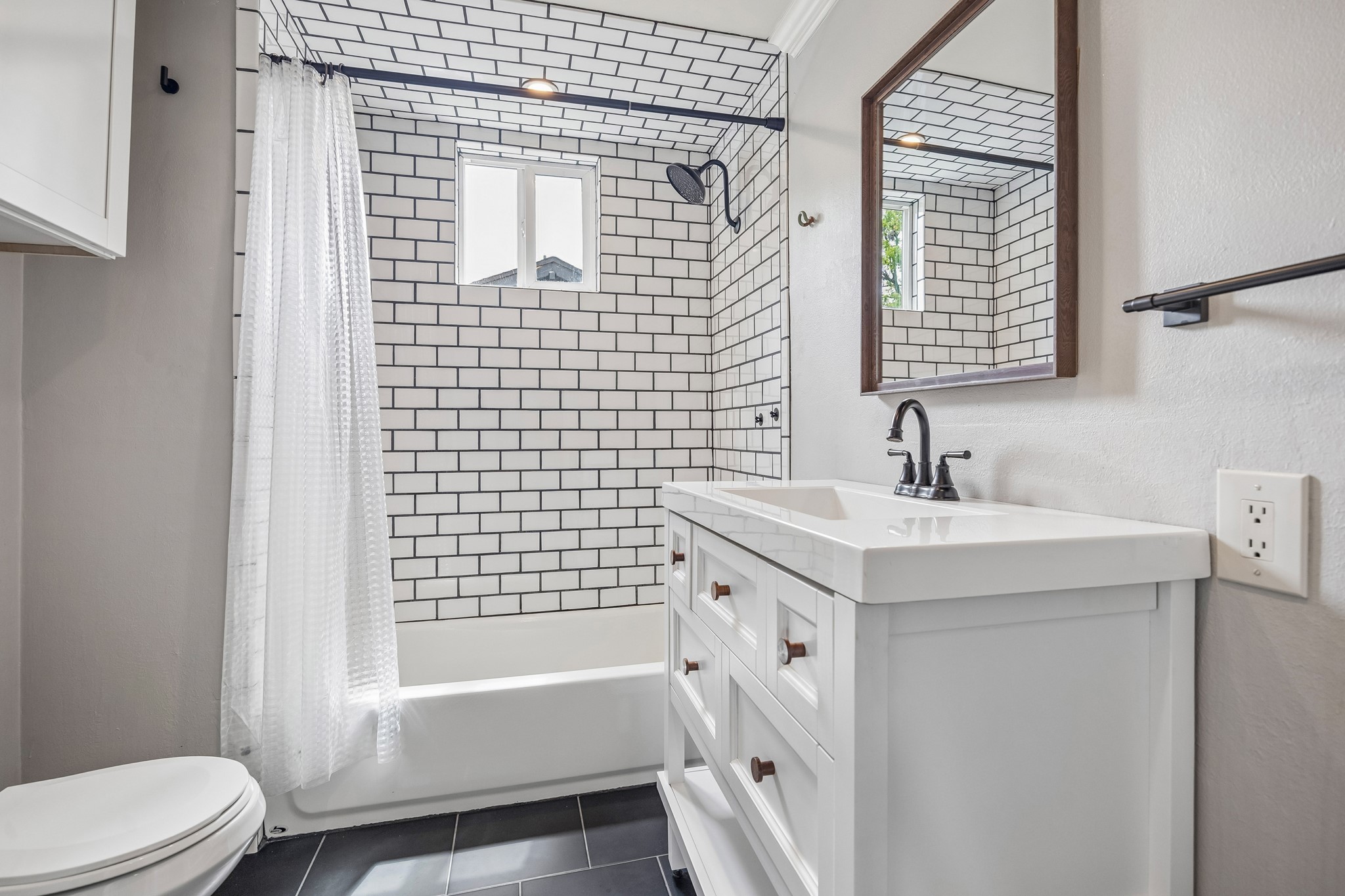 4412 Rusk Street Houston, TX 77023 - Photo 22 of 44 Beautifully & extensively renovated secondary bath features all of the latest finishes, with exquisite tile bath surround, updated vanity, fixtures & hardware!