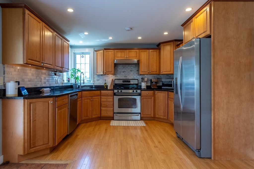 3642 Pawtucket Avenue Riverside, RI 02915 - Photo 3 of 39 a kitchen with granite countertop wooden floors stainless steel appliances and sink