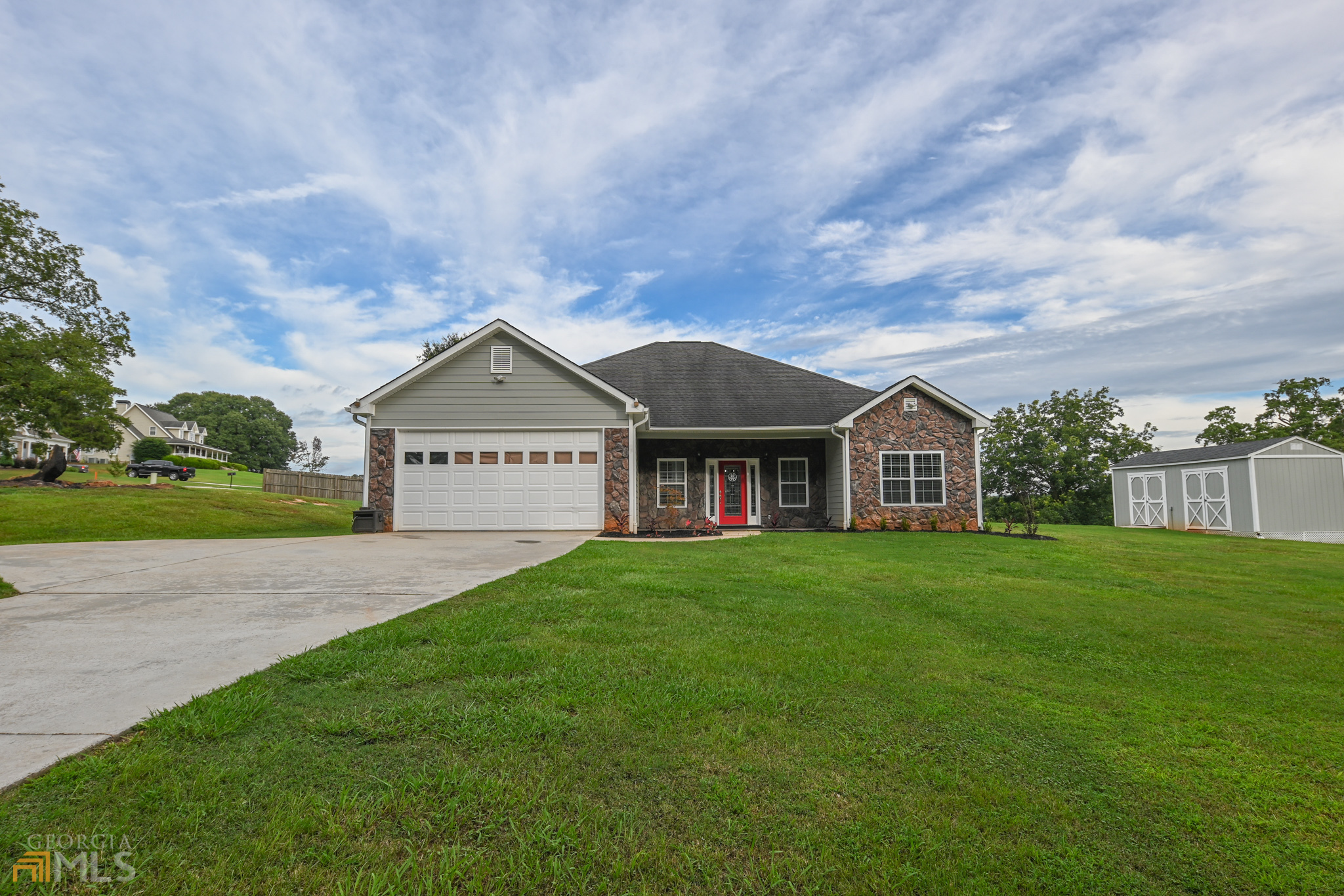 a view of a big house with a big yard and large trees