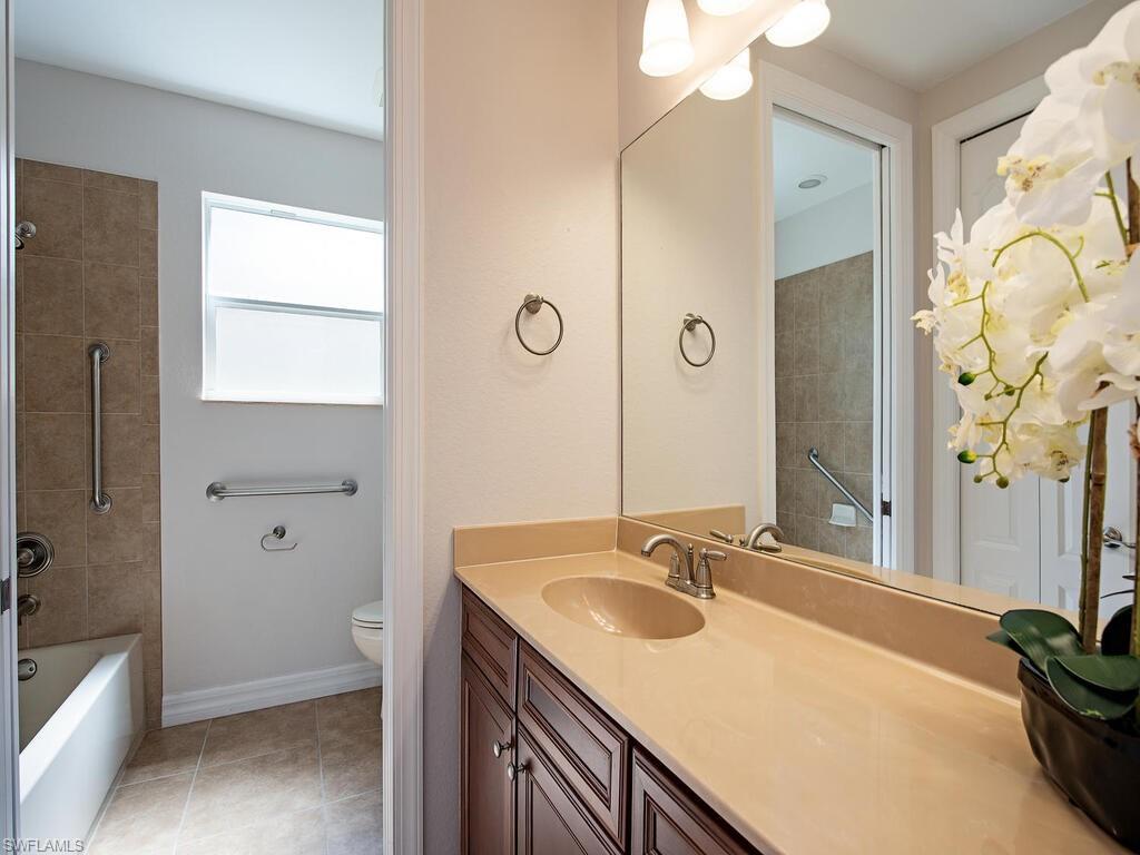431 1st Avenue North Naples, FL 34102 - Photo 15 of 19 a bathroom with a granite countertop sink and a mirror