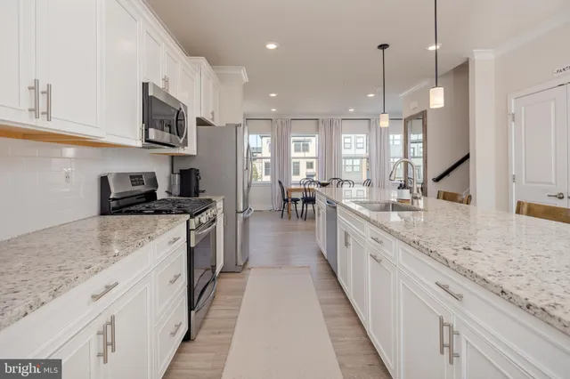 a large kitchen with stainless steel appliances kitchen island granite countertop lots of counter space a sink and a stove