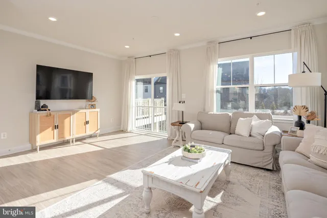 a living room with furniture a flat screen tv and a large window