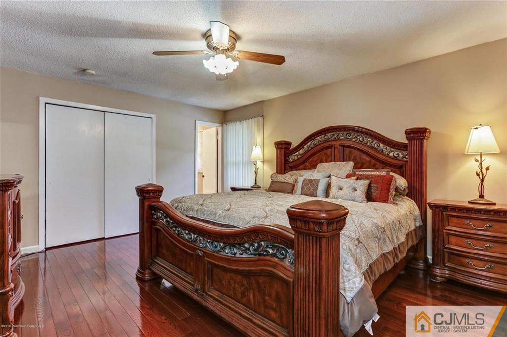 97 Hickory Hill Road Jackson, NJ 08527 - Photo 14 of 24 a bedroom with a bed and a chandelier