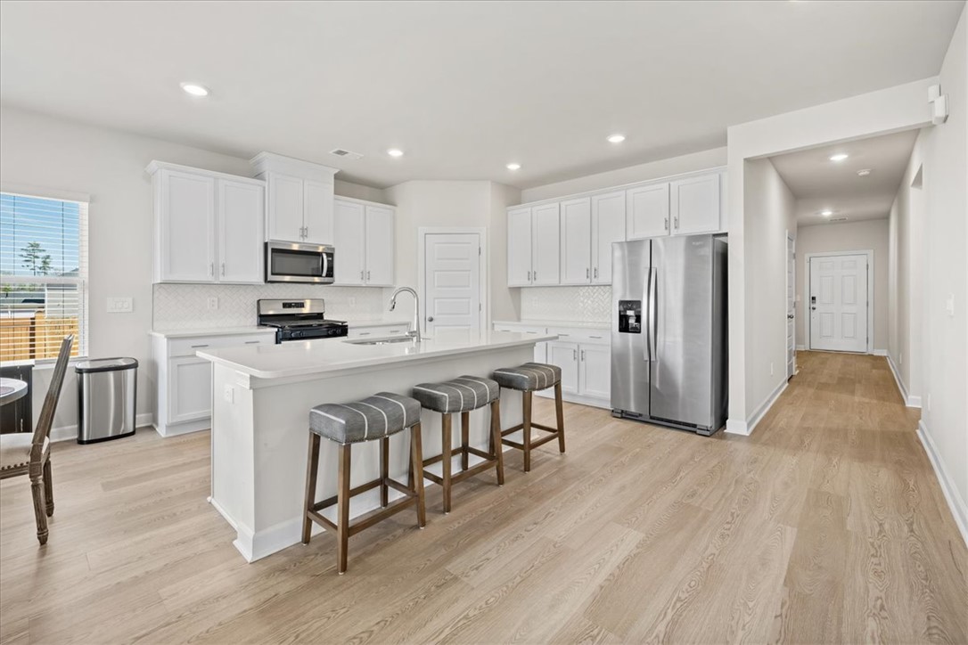 106 Purcell Way Easley, SC 29642 - Photo 6 of 39 This bright kitchen features modern appliances, a kitchen island, and light-toned flooring.